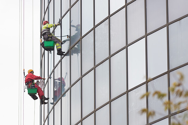 professionals cleaning the windows on commercial building