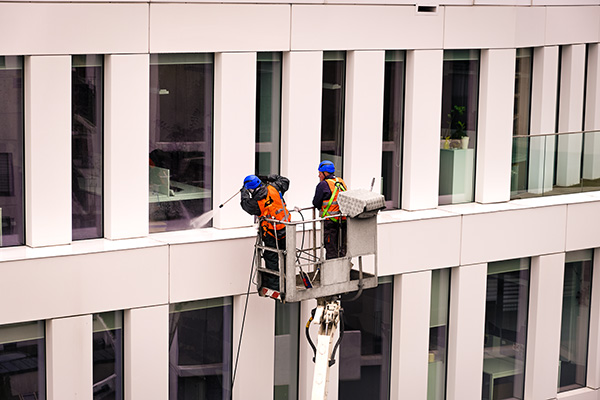 professionals on lift cleaning windows on commercial property