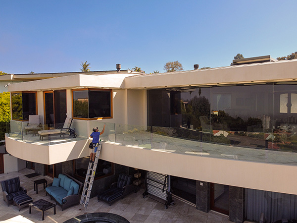 professional cleaning glass wall siding on walkway
